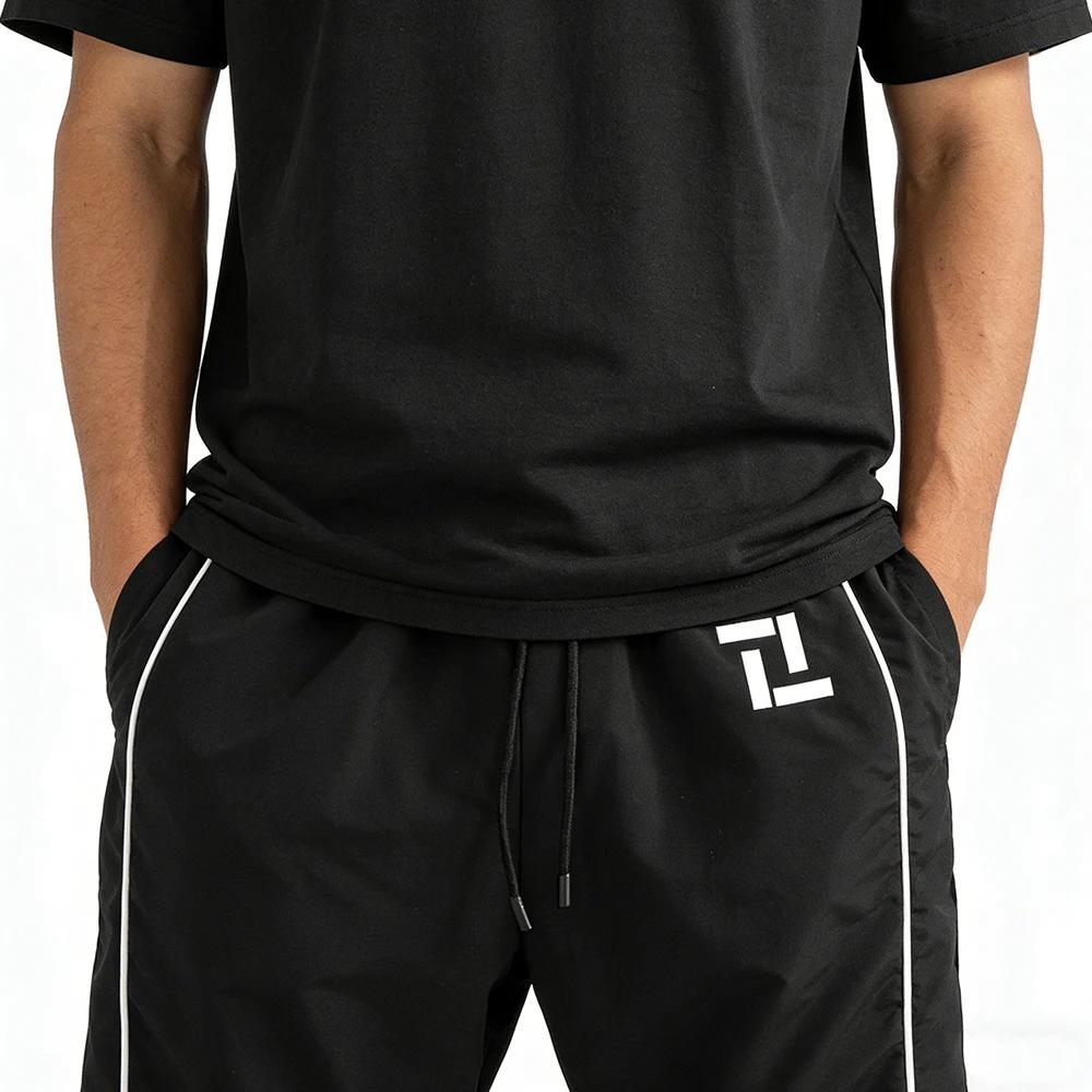 Pantalon de survêtement d'entraînement de fitness pour homme noir avec rayures latérales blanches imprimé géométrique pour sport et loisirs