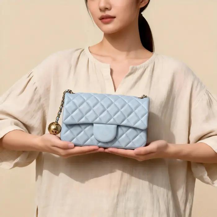 Un mini sac bandoulière matelassé bleu frais avec une chaîne dorée et un fermoir à verrou, doté d'un